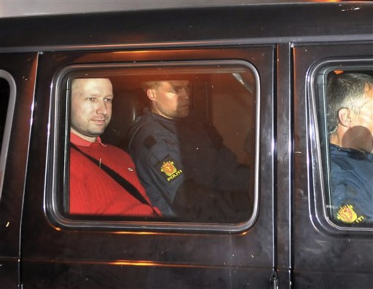Suspect Anders Behring Breivik, left, sits in an armored police vehicle during this arrest.